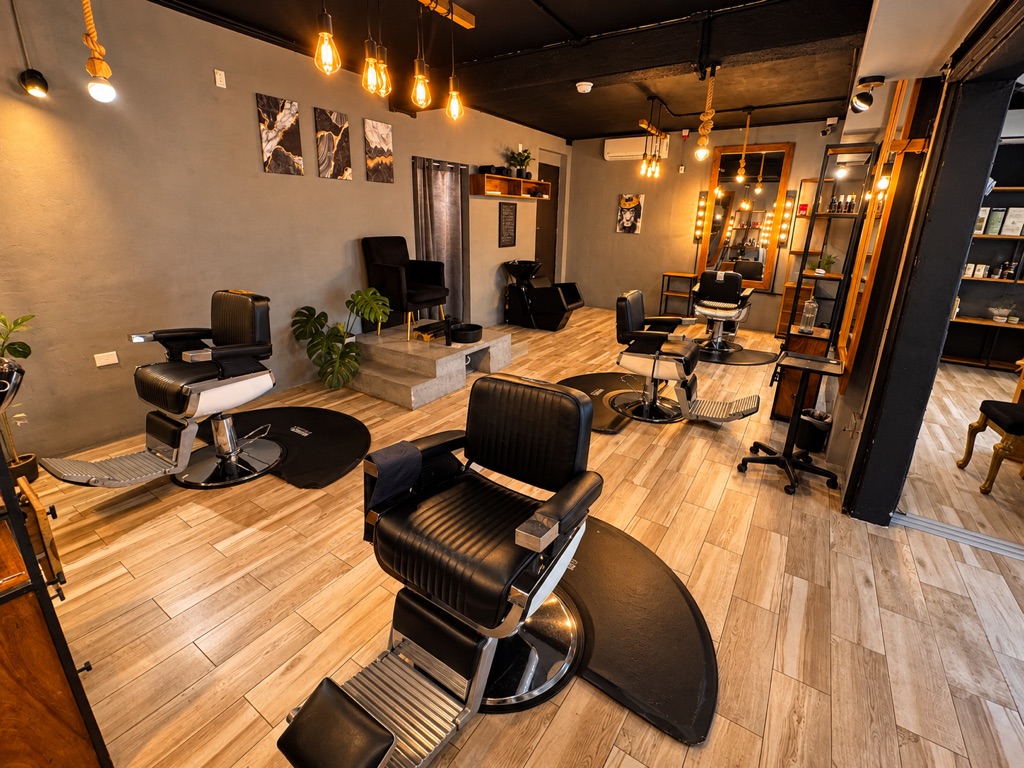 Sillones de barbero de piel negra bajo lámparas Edison de luz cálida