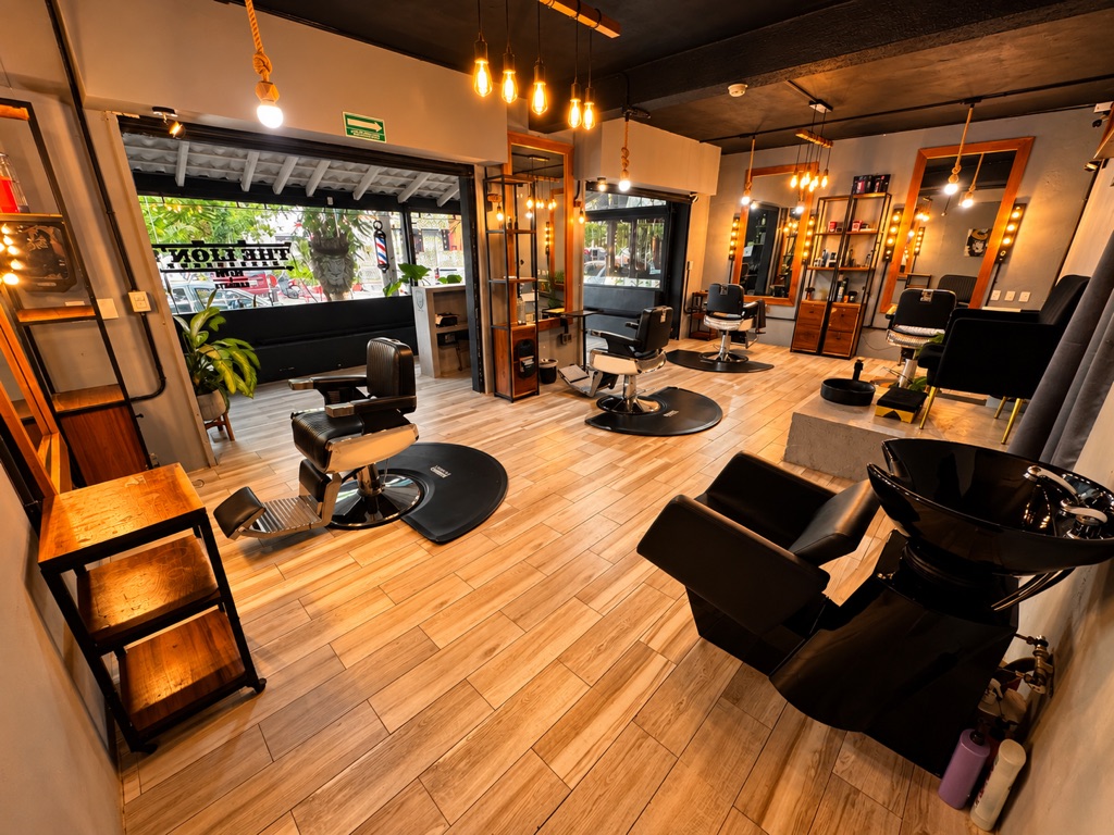 Interior de The Lion's Barbershop: sillones de barbero, lavacabezas y espejos con marco de madera